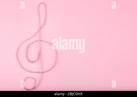 Treble clef sign made of rope on pink background Stock Photo