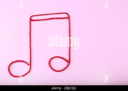 Music note sign made of rope on purple background Stock Photo