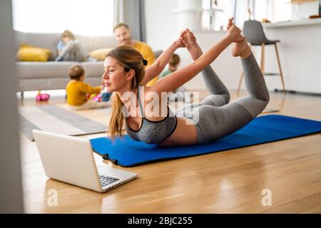 Active sportswoman exercising and smiling at home Stock Photo