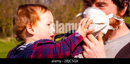 Father and son playing with a face mask outside Stock Photo
