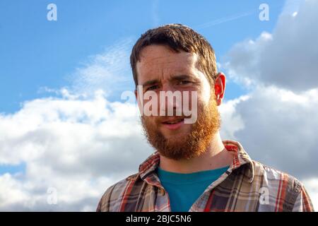 British man with a ginger beard looking amused Stock Photo