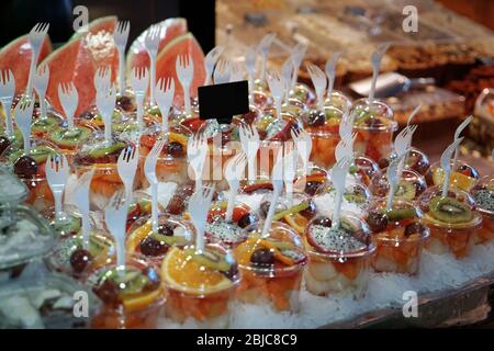 Fresh fruit mix in plastic cups on market showcase Stock Photo