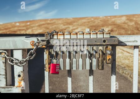 Padlocks on a gate of the Glascarnoch Dam in Scotland. Padlocks are portable locks with a shackle that may be passed through an opening to prevent use Stock Photo