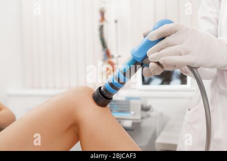 Extracorporeal Shockwave Therapy ESWT. Effective non-surgical treatment for pain. Physical therapy of knee with shock waves.Pain relief, normalization Stock Photo