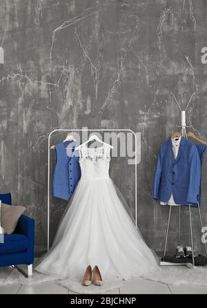 Bride dress and groom suit in dressing room indoors Stock Photo