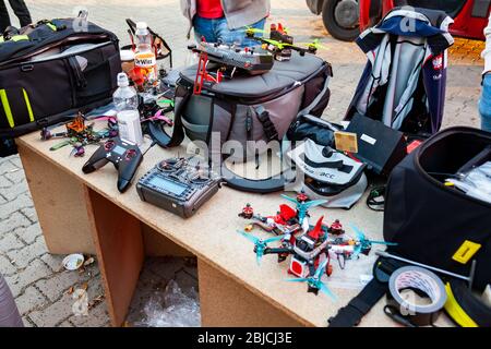 Drone race equipment, drones, remote controllers and batteries, bags and different accessories laying on the table at AGH drone racing event Stock Photo
