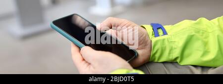 Close-up male hands in jacket hold smartphone Stock Photo