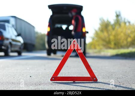 Red warning triangle on asphalt road. Emergency stop concept Stock Photo