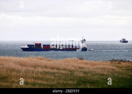 Around the UK - Ensemble, a container ship passing Point Lynas ( Trwyn Eilian ) , Anglesey, with the Pilot boat following behind. Stock Photo
