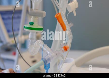 Respiratory connection tube, HME filter, carbon dioxide sensor and suction catheter, patient connected to medical ventilator in ICU in hospital. Stock Photo