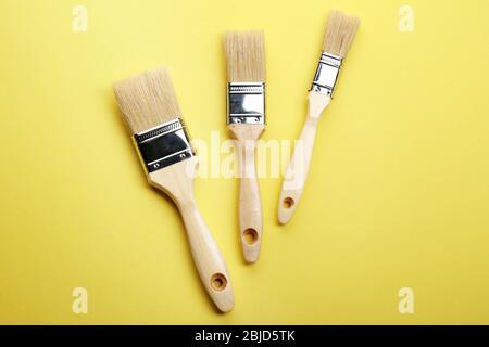 Three brushes on yellow background