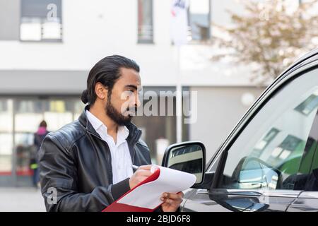 Service technician working in a car rental with protocol Stock Photo