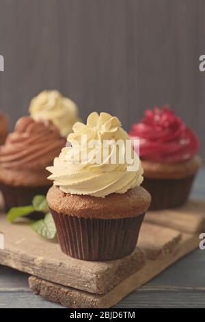 Tasty chocolate cupcake on wooden stand, close up Stock Photo