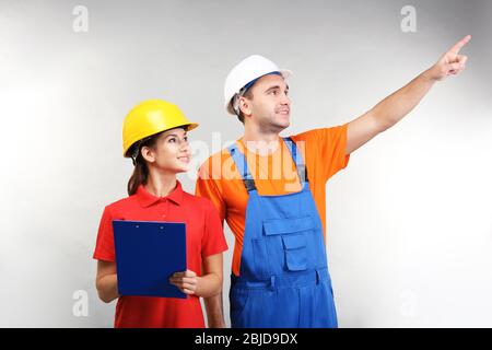 Warehouse workers with clipboard discussing something, on light background Stock Photo