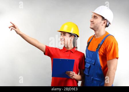 Warehouse workers with clipboard discussing something, on light background Stock Photo