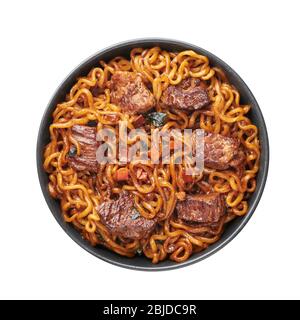 Ram-Don or Chapaguri noodles with beef steak in black bowl isolated on white background. Jjapaguri is a popular south korean dish with ramen and udon Stock Photo