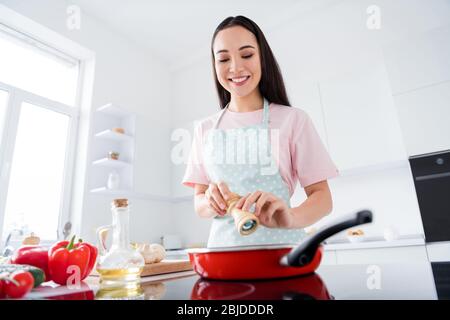 Portrait of her she nice attractive lovely focused busy cheerful careful housewife making delicious meal lunch adding spices weight loss lifestyle in Stock Photo