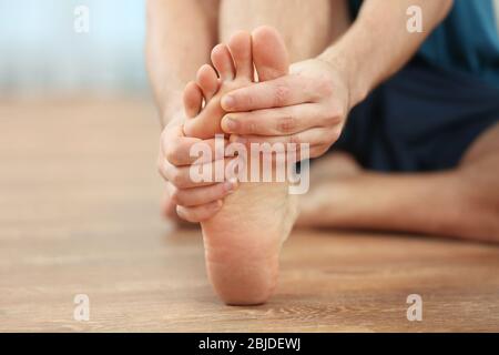 Young man suffering from podalgia at home, closeup Stock Photo