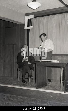 1960s, historical, amateur dramatics, inside on a small stage, two male actors rehearsing a play, England, UK. Before television and the development of home entertainment, many people were involved with a local theatre group, which put on and performed plays. Stock Photo