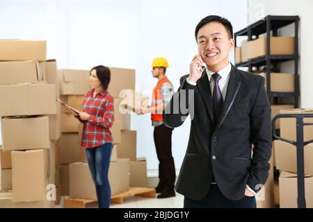 Manager speaking by cellphone at logistic company warehouse Stock Photo