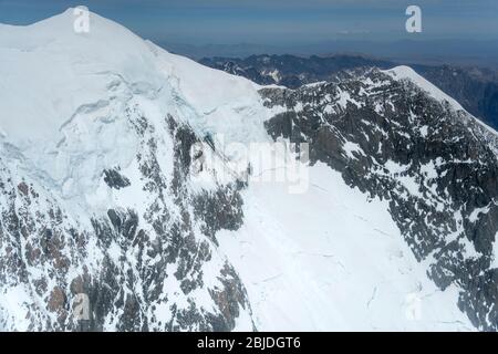 aerial, from a glider, with rocky cliffs and snow landslides at  Mt. Cook range overhanging ridge, shot in bright spring light from north-west, Canter Stock Photo