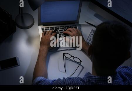 Young programmer working at home late in evening Stock Photo