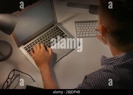 Young programmer working at home late in evening Stock Photo