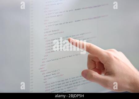 Hand of programmer showing something on pc monitor, closeup Stock Photo