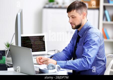Handsome young programmer working in office Stock Photo
