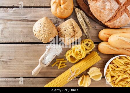 Breads and different types of pasta on a wooden  background, copy space. Stock Photo