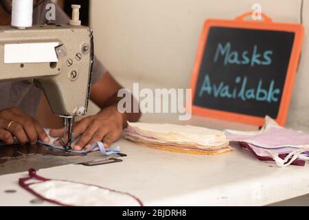 Small business of mask producing and selling at home in India due shortage of medical masks during covid-19 or coronavirus pandemic - Using Sewing Stock Photo