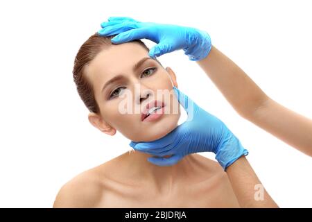 Hands touching female face on white background. Plastic surgery concept Stock Photo