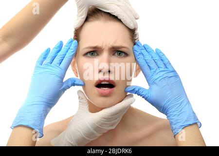 Hands touching female face on white background. Plastic surgery concept Stock Photo