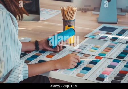 Fashion designer working desk with colorful sewing thread and fabric sample Stock Photo