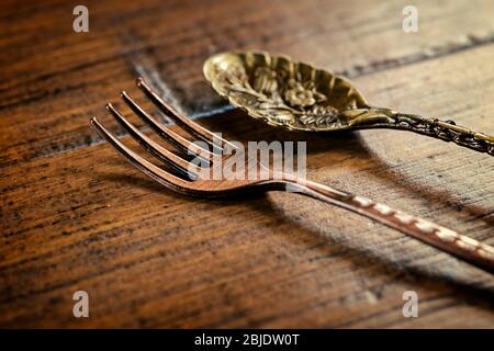 Old fashioned vintage fork and spoon on wooden table Stock Photo