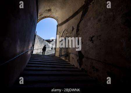 The girl at the end of the tunnel with stairway in Palazzo Pitti, Florence, Tuscany, Italy Stock Photo