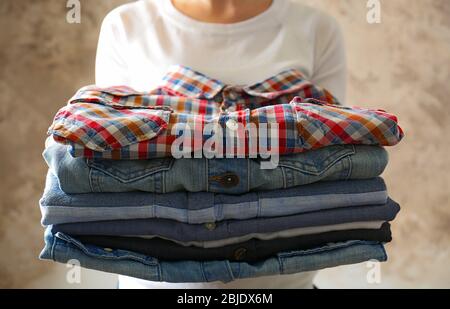 Woman holding folded clothes in hands, closeup Stock Photo