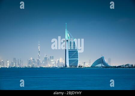 Viewing Dubai cityscape across the sea after sunset. Dubai, United Arab Emirates. Stock Photo