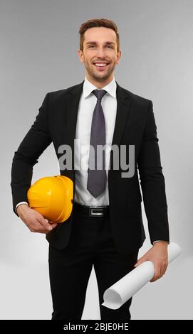 Handsome engineer with drawing on light background Stock Photo