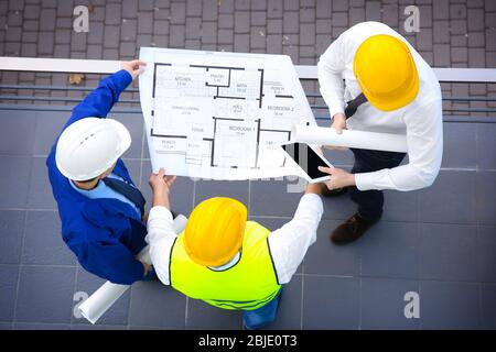 Engineer and workers discussing project of new building Stock Photo