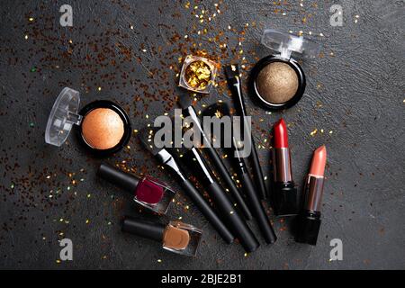 Makeup products and decorative cosmetics on pink background flat lay