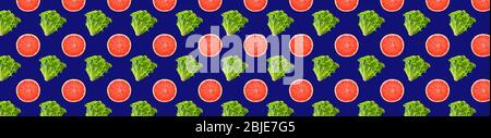 Creative seamless pattern food. Fresh mix of green gentile lettuce salad and grapefruit slices on classic blue background. Full depth of field. Horizo Stock Photo