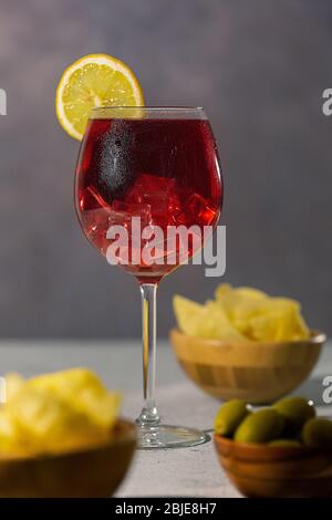 unhealthy afternoon snack with chips and green olives on grey concrete texture. Stock Photo