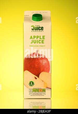 The Juice company Apple juice carton drink isolated on a spring yellow background with reflection. Stock Photo
