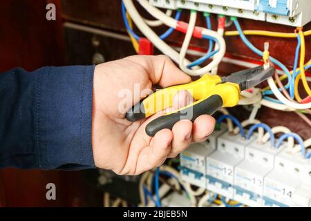 Electrician connecting wires in distribution board, closeup Stock Photo