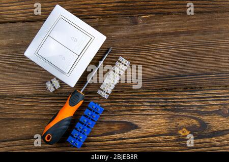 Tools of an electrician installer or Builder on a dark wooden table. The concept of making an estimate or list of construction materials for Stock Photo