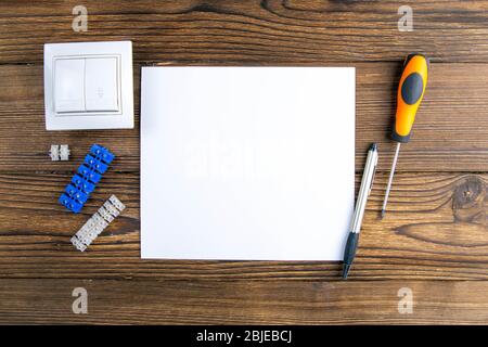 Open Notepad and tools of an electrician installer or Builder on a gray wooden table. The concept of making an estimate or list of construction Stock Photo