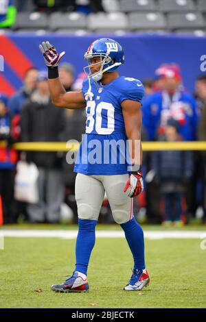 Wide receiver Victor Cruz (80) of the New York Giants and kicker Lawrence  Tynes (9) of the New York Giants hold the championship trophy at the end of  Super Bowl XLVI on