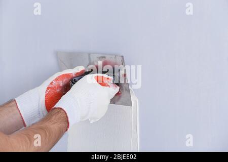 Builder using plastering tool for finishing wall Stock Photo