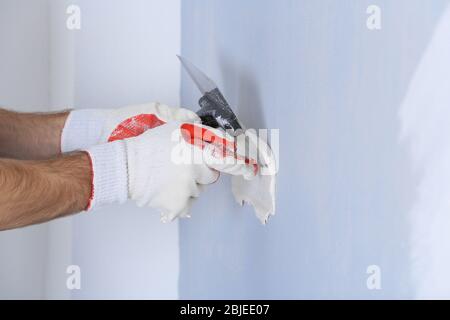 Builder using plastering tool for finishing wall Stock Photo